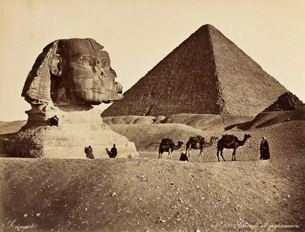 Egyptian men on camels in front of pyramid